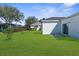 Lush backyard features green grass, mature landscaping, and view of the house at 8338 Maybelle Dr, Weeki Wachee, FL 34613