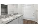 Elegant bathroom with a double sink vanity, granite countertops, and a tiled shower/tub combination at 8338 Maybelle Dr, Weeki Wachee, FL 34613