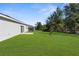Large backyard with lush green grass and screened-in porch at 8828 Mississippi Run, Weeki Wachee, FL 34613