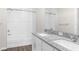 Bathroom features a shower-tub combo, granite countertop vanity with double sinks, and modern fixtures at 8828 Mississippi Run, Weeki Wachee, FL 34613