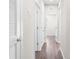 Long hallway with white walls and dark wood-look flooring at 8828 Mississippi Run, Weeki Wachee, FL 34613