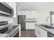 Modern kitchen features stainless steel appliances, granite countertops, and white cabinetry at 8828 Mississippi Run, Weeki Wachee, FL 34613