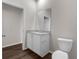 Bathroom featuring a granite countertop vanity, white cabinets, and a modern toilet at 9062 Wade St, Brooksville, FL 34613