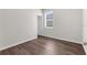 Bright bedroom with wood-look flooring, a window, and fresh neutral paint at 9062 Wade St, Brooksville, FL 34613
