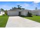 Charming single-story home with a well-maintained lawn and a two-car garage on a sunny day at 9062 Wade St, Brooksville, FL 34613
