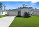 Charming single-story home with a well-maintained lawn and a two-car garage on a sunny day at 9062 Wade St, Brooksville, FL 34613