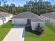 Well-maintained, single-story home featuring a two-car garage, manicured lawn, and neutral color scheme at 9062 Wade St, Brooksville, FL 34613