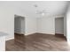 Spacious living room with dark wood flooring and a ceiling fan, illuminated by natural light at 9062 Wade St, Brooksville, FL 34613