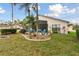 Lush backyard featuring tropical trees, seating area with hammock, and well manicured lawn at 9336 Creekside Ct, Hudson, FL 34669