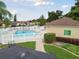 Community pool with a white fence, lounge chairs, pool rules sign, and well-maintained landscaping at 9336 Creekside Ct, Hudson, FL 34669