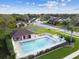 Aerial view of the community pool featuring ample seating, lush landscaping and well maintained area at 9336 Creekside Ct, Hudson, FL 34669