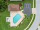 Aerial view of a community pool with lounge chairs, a picnic area, and mature landscaping at 9336 Creekside Ct, Hudson, FL 34669
