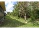 View of the backyard with healthy green grass, lush trees, and beautiful greenery at 9405 Palm Haven Ct, New Port Richey, FL 34655