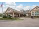 Exterior view of the clubhouse, featuring covered entrance, U.S. flag, and well-maintained landscaping at 9405 Palm Haven Ct, New Port Richey, FL 34655