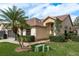 Low angle view of a charming single Gathering home featuring a well maintained lawn and mature palm trees at 9405 Palm Haven Ct, New Port Richey, FL 34655