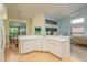 Open concept kitchen featuring white cabinets and views into the living room and dining area at 9405 Palm Haven Ct, New Port Richey, FL 34655