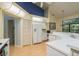 Well lit kitchen featuring a breakfast bar, white appliances, and wood flooring at 9405 Palm Haven Ct, New Port Richey, FL 34655