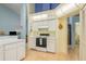 Clean kitchen with white cabinets, laminate countertops, an electric range, and tile backsplash at 9405 Palm Haven Ct, New Port Richey, FL 34655