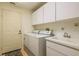 Laundry room with storage cabinets and a utility sink at 9405 Palm Haven Ct, New Port Richey, FL 34655