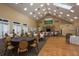 Large meeting room with tables, chairs, wood floors, and golf course painting above the fireplace at 9405 Palm Haven Ct, New Port Richey, FL 34655