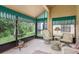 Enclosed sunroom featuring tiled floors, comfortable wicker furniture and views of the outdoors at 9405 Palm Haven Ct, New Port Richey, FL 34655