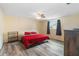 Bedroom features a red bedspread, wood floors, and a ceiling fan at 10736 Queens Rd, Port Richey, FL 34668