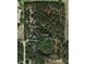 Aerial view shows a large parcel of land, featuring a cottage, a duplex, a garage, and a pond at 11617 Duda Rd, Hudson, FL 34667