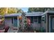 The exterior of this cozy home features a unique stone chimney and charming green accents at 11617 Duda Rd, Hudson, FL 34667