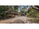 Exterior shot of property featuring multiple small buildings and a covered structure in a wooded landscape at 11617 Duda Rd, Hudson, FL 34667