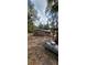 Back view of the home with a neutral color palette and surrounded by mature trees and a large yard at 11617 Duda Rd, Hudson, FL 34667