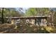Exterior view of a weathered house surrounded by trees and lush vegetation at 11617 Duda Rd, Hudson, FL 34667