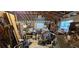 Interior of a messy garage with a bare wooden ceiling, packed with tools and storage containers at 11617 Duda Rd, Hudson, FL 34667