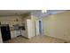 White kitchen featuring black refrigerator, stove, cabinets and tiled floor at 11617 Duda Rd, Hudson, FL 34667