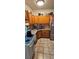 Functional kitchen featuring wooden cabinets, tile countertops, and stainless steel appliances, ready for your touch at 11617 Duda Rd, Hudson, FL 34667