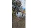 Exterior shot of a weathered outbuilding with a rusty metal roof and old brick foundation at 11617 Duda Rd, Hudson, FL 34667