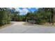 Road leading to the property with a green mailbox with four slots and vehicles in the distance at 11617 Duda Rd, Hudson, FL 34667