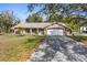 Charming single-story brick home with well-maintained lawn and mature trees for a peaceful curb appeal at 12511 Stone House Loop, Hudson, FL 34667
