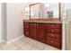 Bathroom with wooden cabinets, granite countertop, and a large mirror at 12724 Circle Lake Dr, Hudson, FL 34669