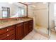 Bathroom with a wooden vanity with a granite countertop, a glass door shower and great lighting at 12724 Circle Lake Dr, Hudson, FL 34669