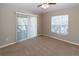 Bedroom featuring neutral carpet, fan, window, and sliding glass door at 12724 Circle Lake Dr, Hudson, FL 34669