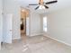 Bright bedroom featuring a ceiling fan, neutral walls and carpet, with ensuite bathroom at 12724 Circle Lake Dr, Hudson, FL 34669
