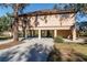 Charming raised home showcasing a neutral stucco exterior, carport and convenient access stairs at 12724 Circle Lake Dr, Hudson, FL 34669