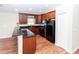 Kitchen with black appliances and countertops, wood cabinets, and wood-look flooring at 12724 Circle Lake Dr, Hudson, FL 34669
