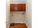 A laundry room with wood floors, brown cabinets, and appliance hookups at 12724 Circle Lake Dr, Hudson, FL 34669