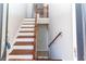Open staircase with wood banister and white risers and wood treads leading to upper level at 12724 Circle Lake Dr, Hudson, FL 34669