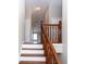 Stairway with wood and white stairs and wood railing leading to an upstairs room with natural light at 12724 Circle Lake Dr, Hudson, FL 34669