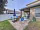 Backyard patio with stone fire pit, chairs, umbrella, and view of the house and fence at 13304 Mandalay Pl, Spring Hill, FL 34609
