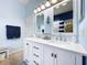 Bathroom featuring double sink vanity with white cabinets, stone countertops, and brushed bronze hardware at 13304 Mandalay Pl, Spring Hill, FL 34609
