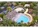 Aerial shot of community pool, splash pad, playground, and clubhouse surrounded by trees at 13304 Mandalay Pl, Spring Hill, FL 34609