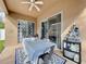 Covered patio with sliding glass doors, outdoor table, and decorative statue at 13304 Mandalay Pl, Spring Hill, FL 34609